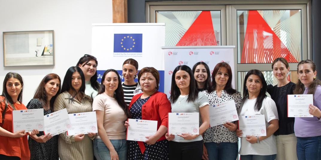 People standing with diplomas 