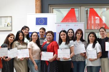 People standing with diplomas 